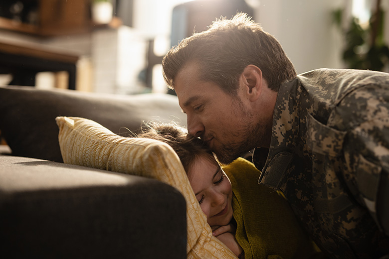 A soldier kissing his daughter's forehead